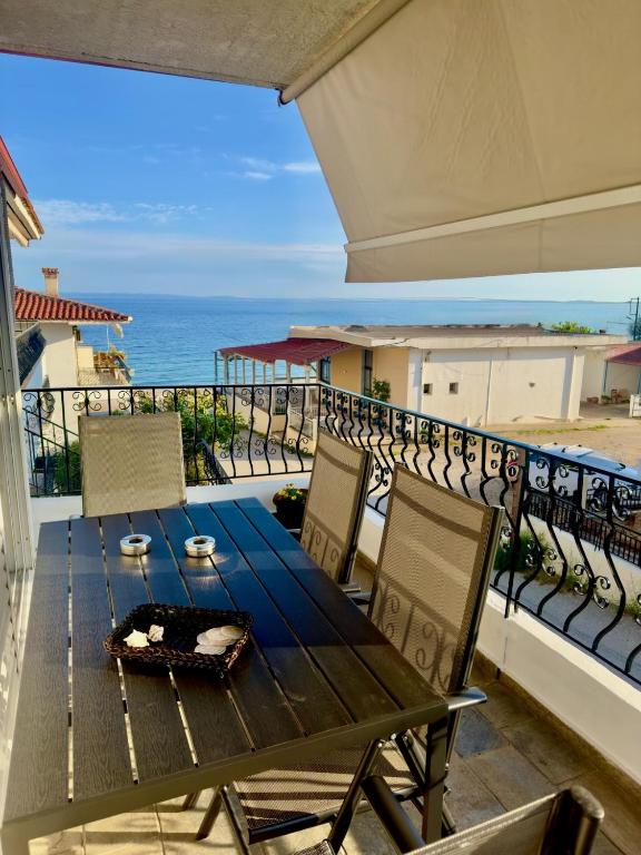 a table and chairs on a balcony with the ocean at VillaKaliba BEACHFRONT HOUSE in Kalives Poligirou