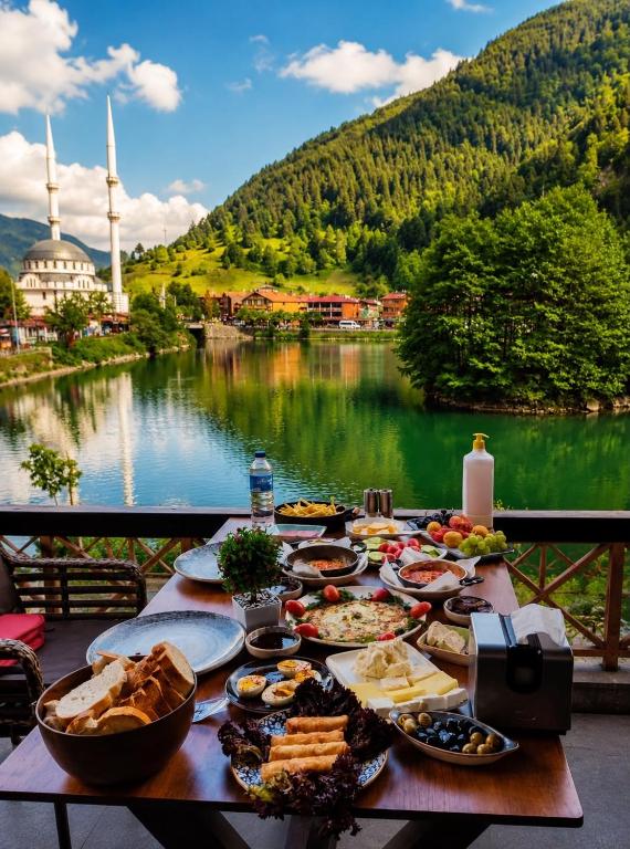 a table with food and a view of a lake at Deal Otel in Uzungöl