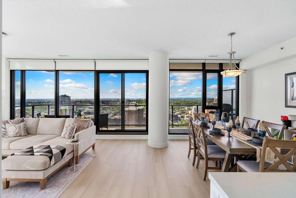 a living room with a couch and a dining room with a table at Nuage 2 Bed 2 Bath 2 Balconies Parking in Calgary