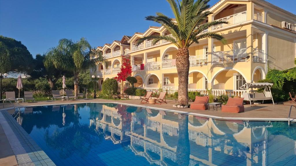 a hotel with a swimming pool in front of a building at Sunflower Apartments & Studios in Laganas