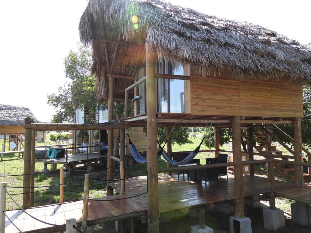 a hut with a hammock and a playground at Ecopayara Hotel Puerto Gaitán in Puerto Gaitán