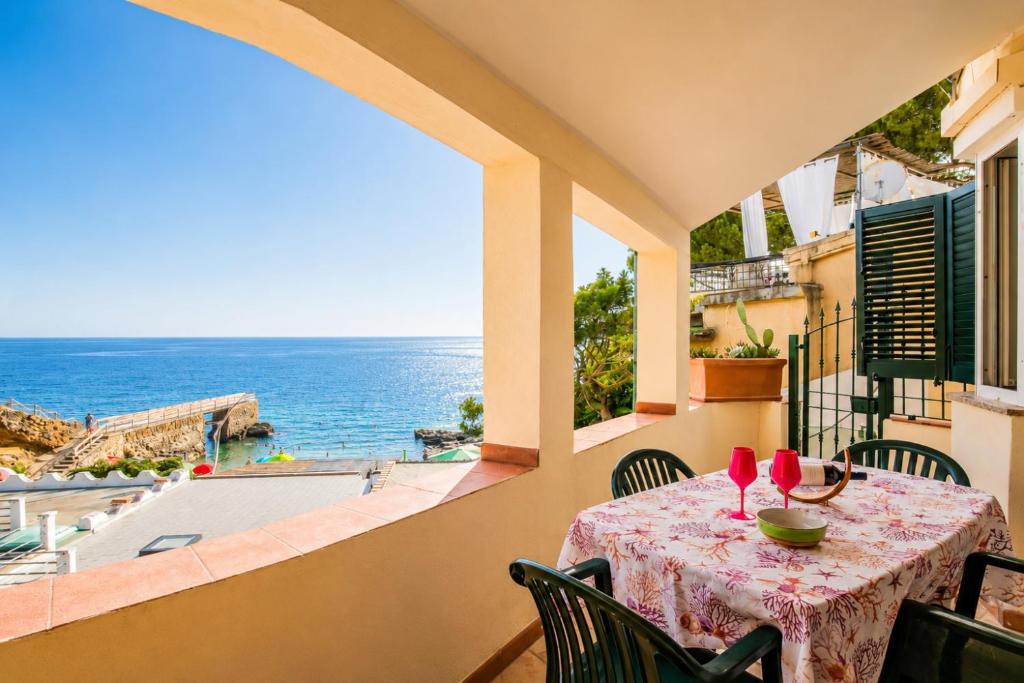 a table on a balcony with a view of the ocean at Casa Stecchi in Capoliveri