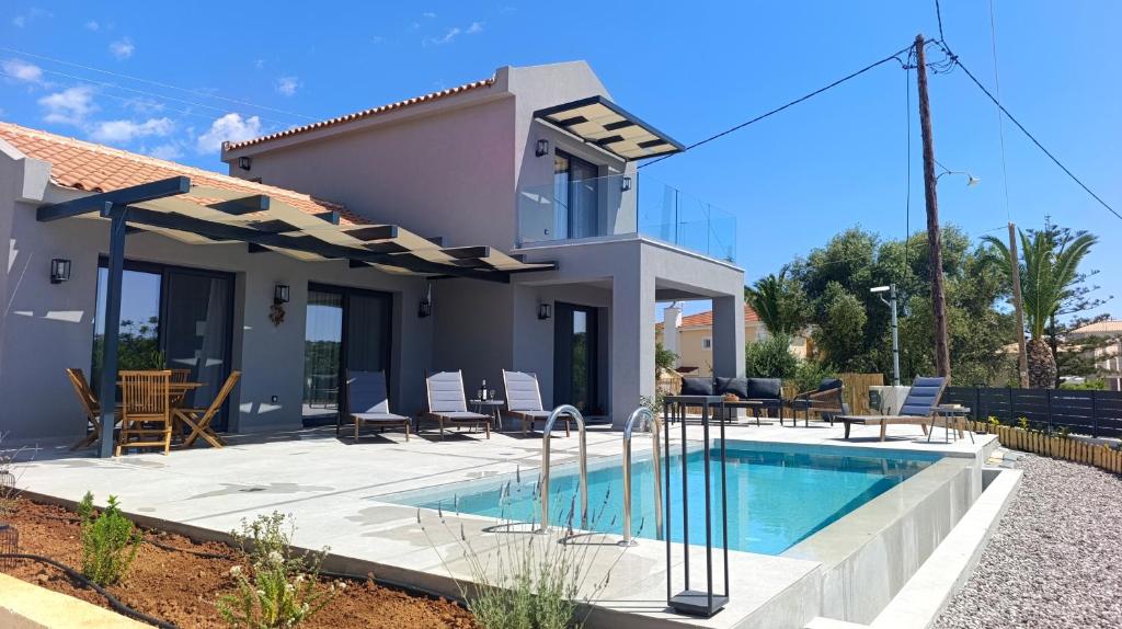 a villa with a swimming pool in front of a house at Villa GEIA in Klísmata