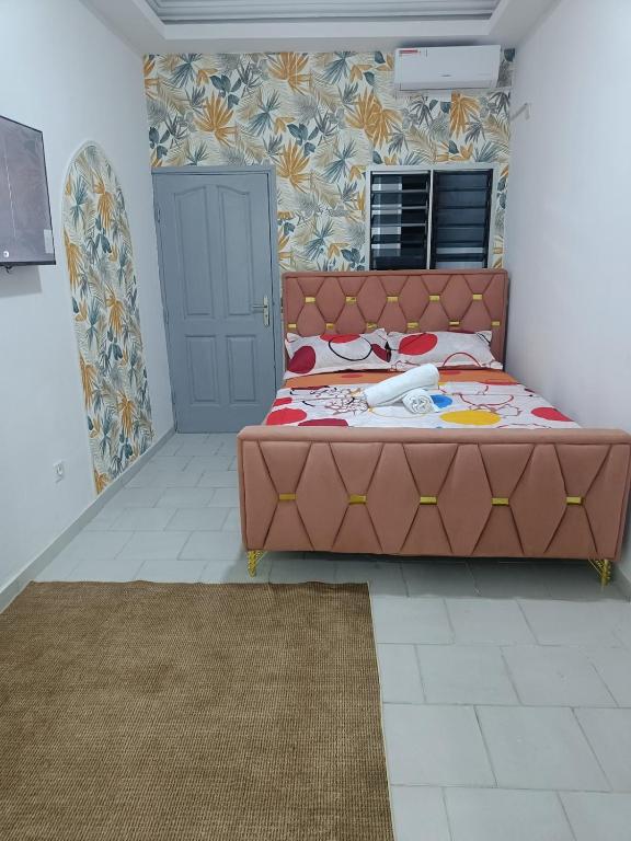 a bedroom with a bed with a brown head board at 1e Studio Moderne au cœur de Cocody 7e tranche- Tout inclus in Cocody