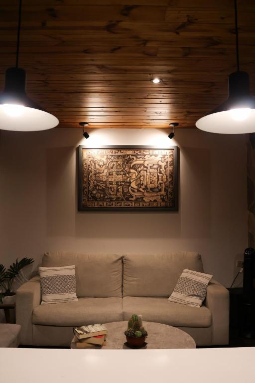 a living room with a couch and a painting on the wall at Jardín de Janaab' in San Antonio Palopó
