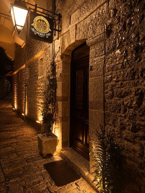a building with a door and a sign on it at Alchemist Inn in Gjirokastër