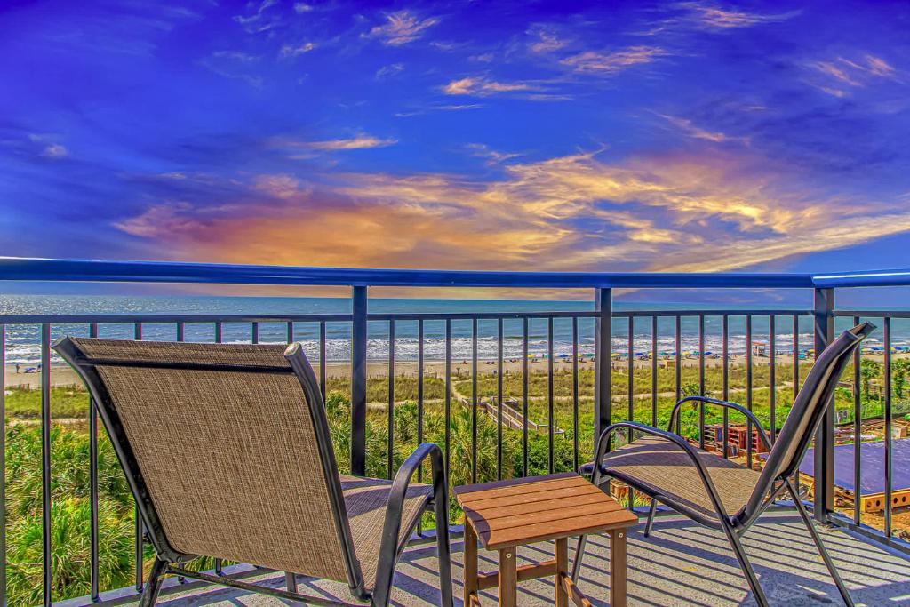 two chairs and a table on a balcony with the ocean at Boardwalk 439 & 440 in Myrtle Beach