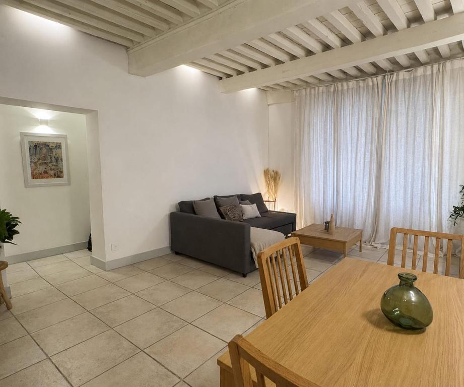 a living room with a couch and a table at Bright Nîmes Center Flat with Terrace in Nîmes