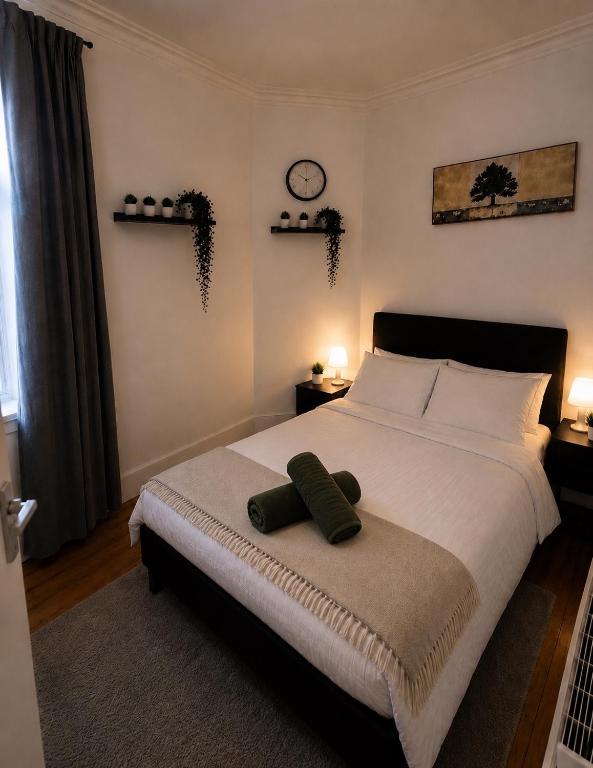 a bedroom with a bed with a green pillow on it at Comfortable 2 Bedroom Flat in Leith in Edinburgh