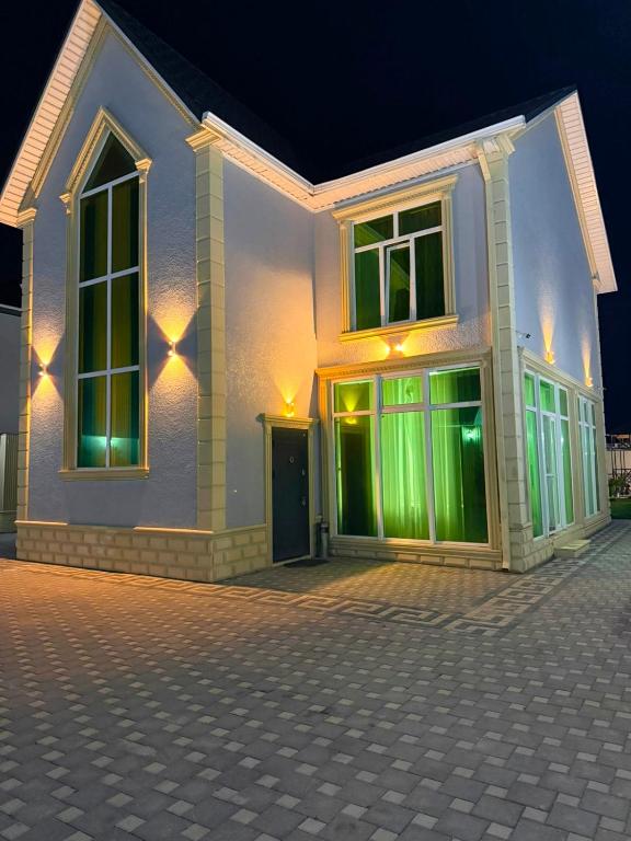 a house with green lights on the side of it at Şuvelan Villa in Baku