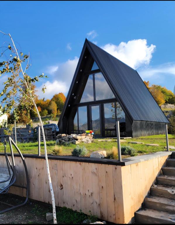 a building with a black roof and stairs at Cottage MATEJ in Podgorica