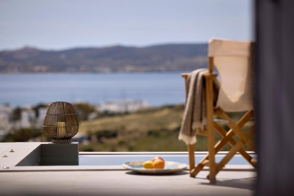 a plate of fruit on a table next to a chair at Milesian Suites in Adamantas
