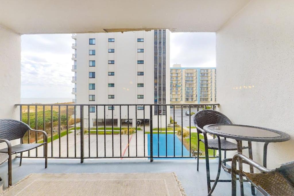 a balcony with a table and chairs and a building at Camelot 203B in Ocean City