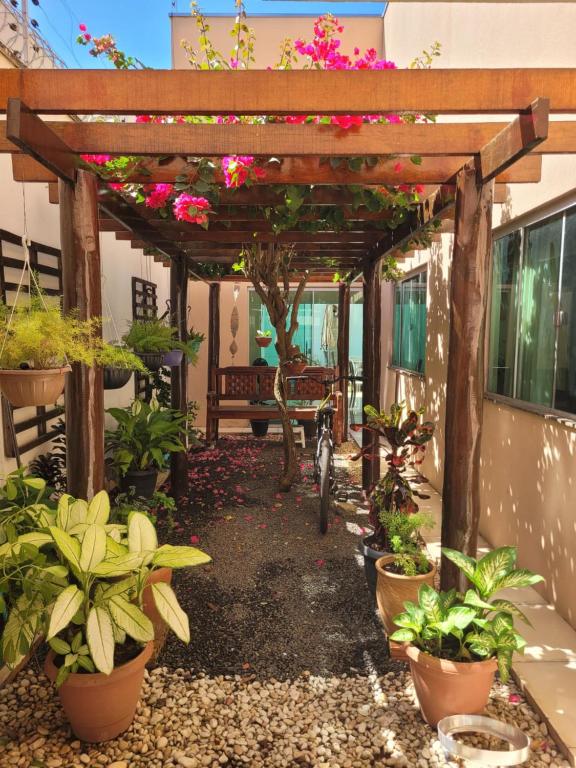 a garden with a pergola with flowers and plants at Santorini House Pousada e Restaurante in Araguaína