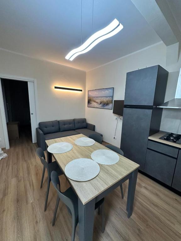 a dining room with a table and a couch at Salsedine house in Punta Marina