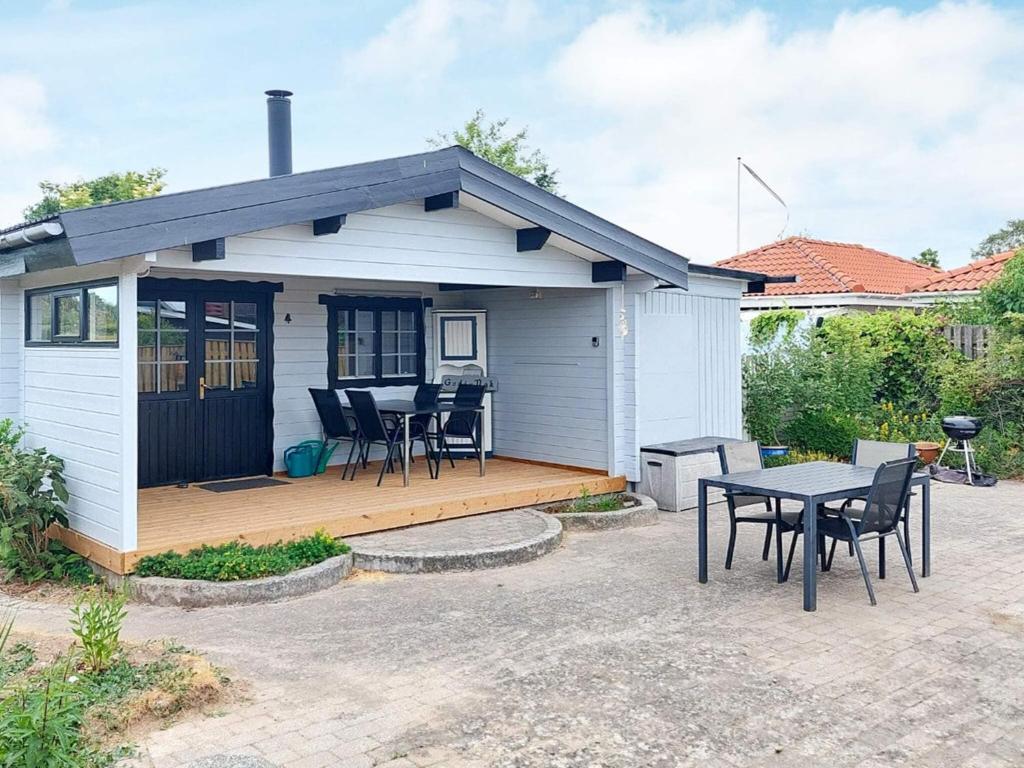 a small white house with a table and chairs at 4 person holiday home in Karrebæksminde-By Traum in Karrebæksminde
