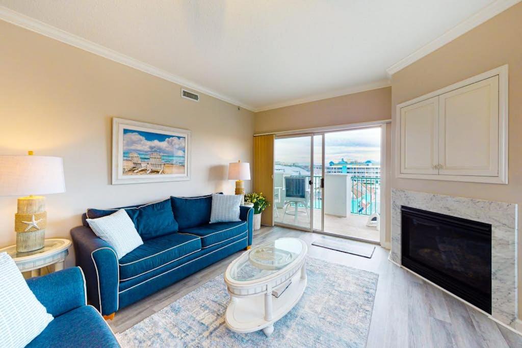 a living room with a blue couch and a fireplace at Avalon 406 in Ocean City