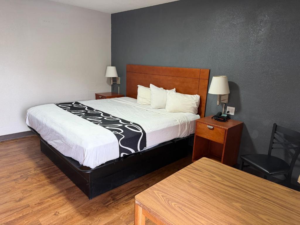 a hotel room with a bed and a table at Regency Inn in Muskogee