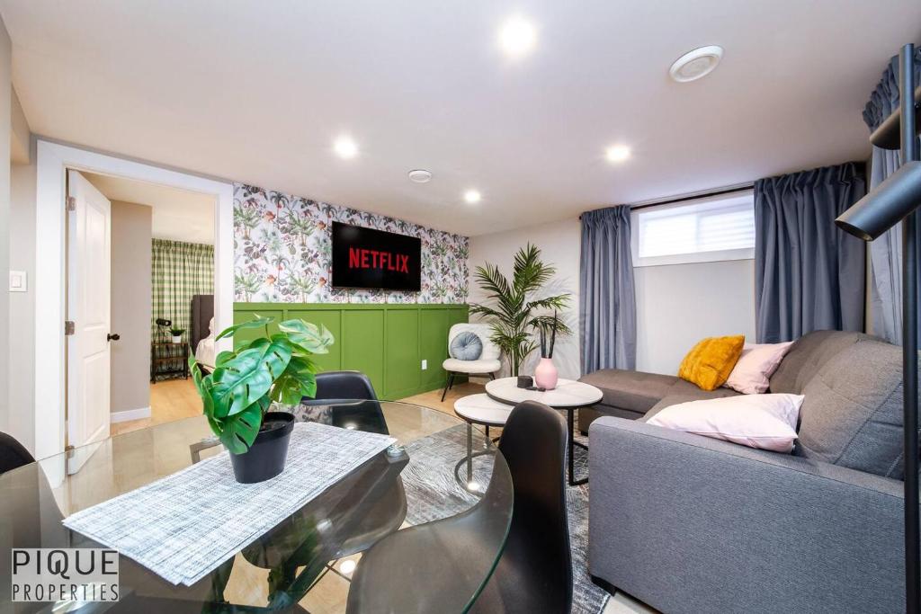a living room with a couch and a tv at Modern Urban Escape -King Bed -Pet Friendly - Free Parking & Netflix - Fast Wi-Fi in Edmonton
