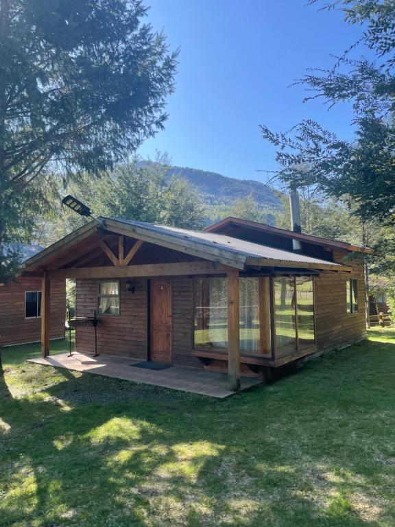 a log cabin with a porch and a deck at Pichares in Pichare