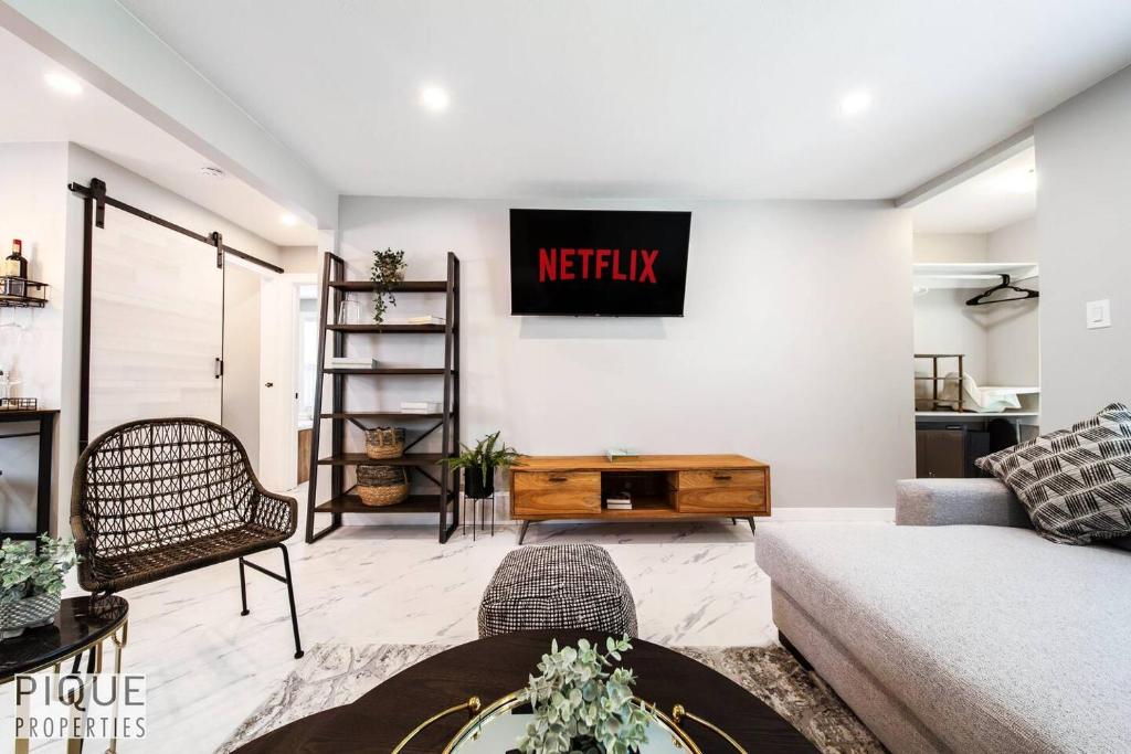 a living room with a couch and a tv on the wall at Park Life Retreat - King Bed - Pet Friendly - Sleeps 6 in Edmonton