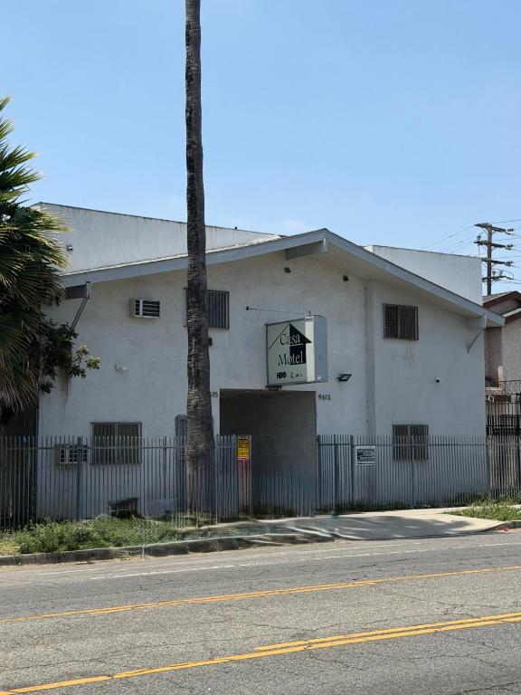 a white building with a sign on the side of it at Casa Motel in Los Angeles