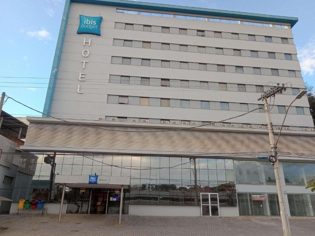 a large white building with a sign on it at ibis budget Barbacena in Barbacena
