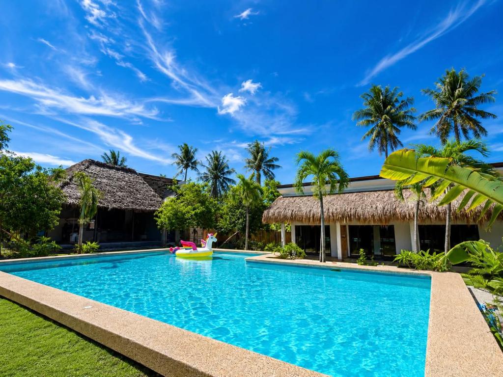 a swimming pool in front of a villa at Anaiah Garden Resort in Moalboal