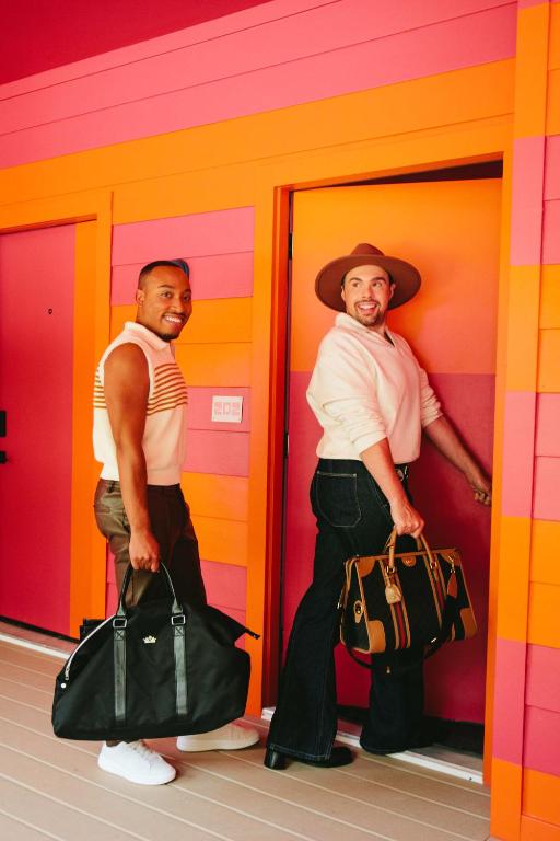 two men standing in a room with their bags at Hotel Hilo - Room 103 in Louisville