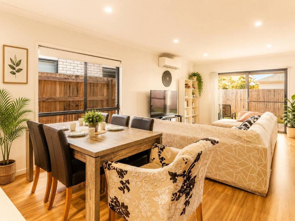 a living room with a table and a couch at Spacious 4B Near Logan with Parking in Marsden