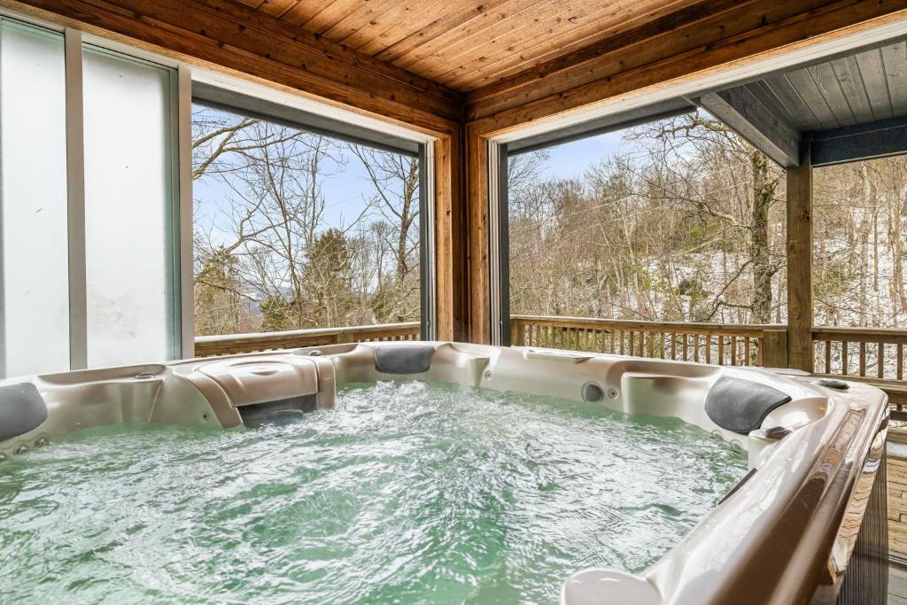 a hot tub in a room with windows at North View Lodge High Country in Banner Elk