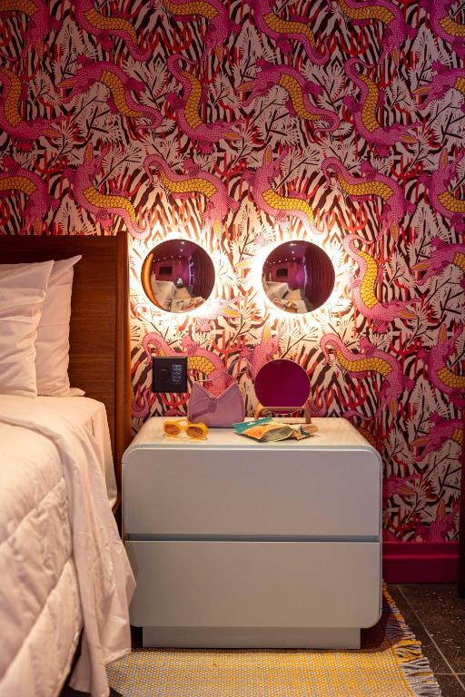 a bedroom with a bed and a table with a mirror at Hotel Hilo - Room 203 in Louisville