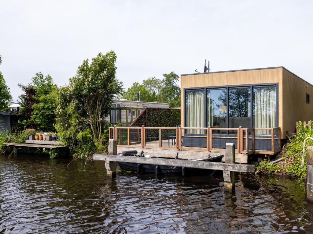 a house on a dock next to a body of water at t Sluisje 8 in Bantega