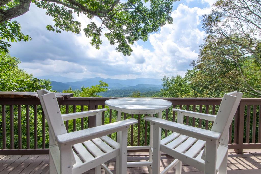 a table and two chairs on a deck with a view at Pinnacle View Lodge in Boone