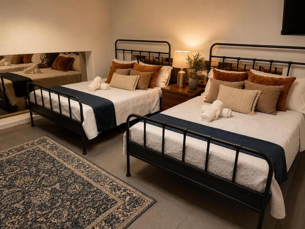 a bedroom with two beds and a rug at Morada Luna Centro Histórico in Mexico City
