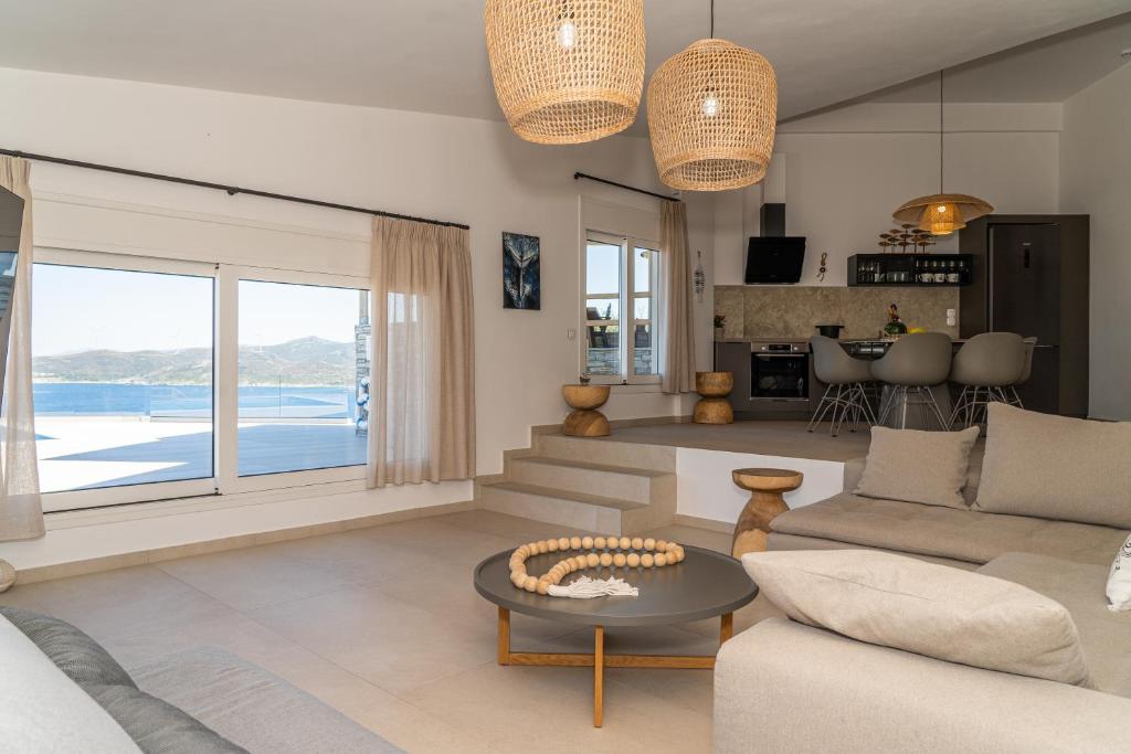 a living room with a couch and a table at PETRA Luxury Villas in Agioi Apostoli