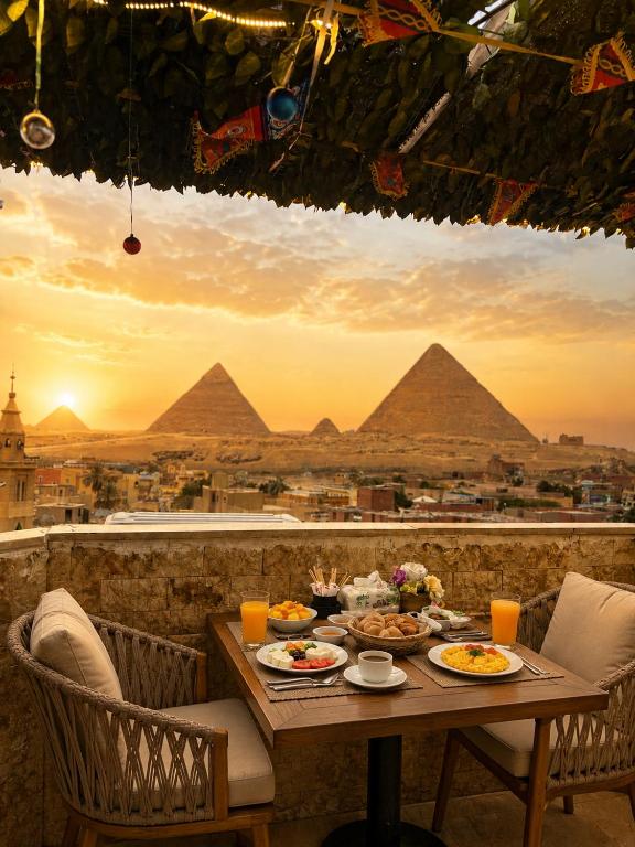 a table with food on it with a view of pyramids at Sun Hotel in Cairo