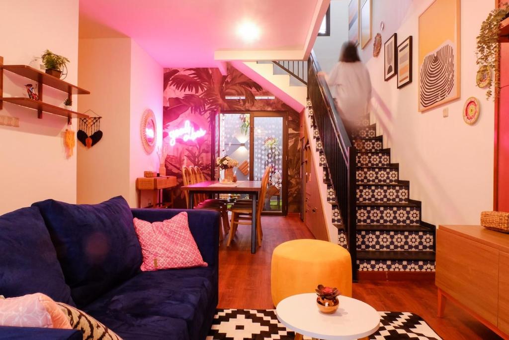 a living room with a blue couch and a staircase at Kalysandria Home in Padasul
