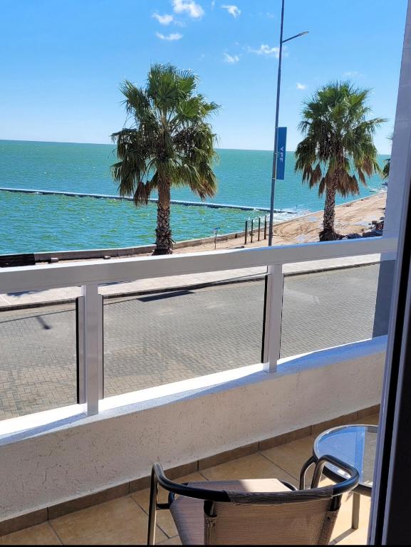a balcony with a view of the beach and palm trees at Amanecer Petit in Miramar