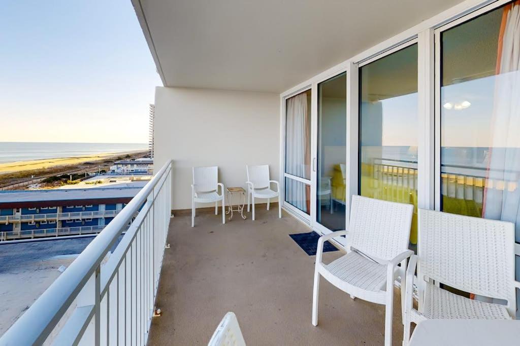 a balcony with white chairs and a view of the ocean at Carousel 706 in Ocean City
