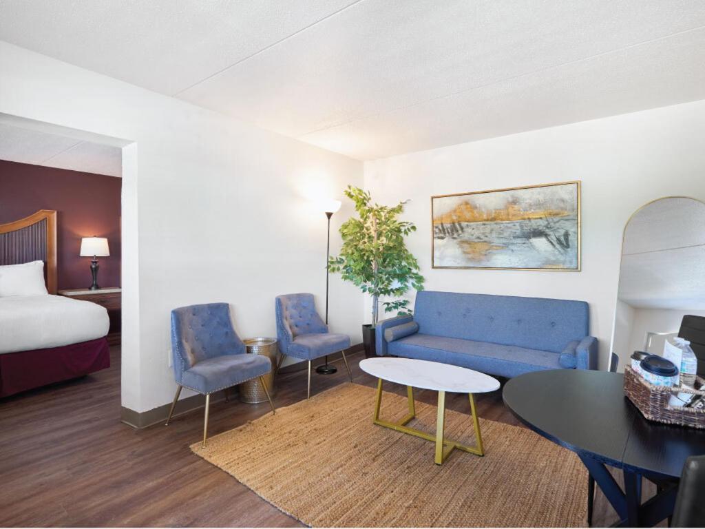 a hotel room with a bed and a couch and a table at The Derby Inn in Hot Springs