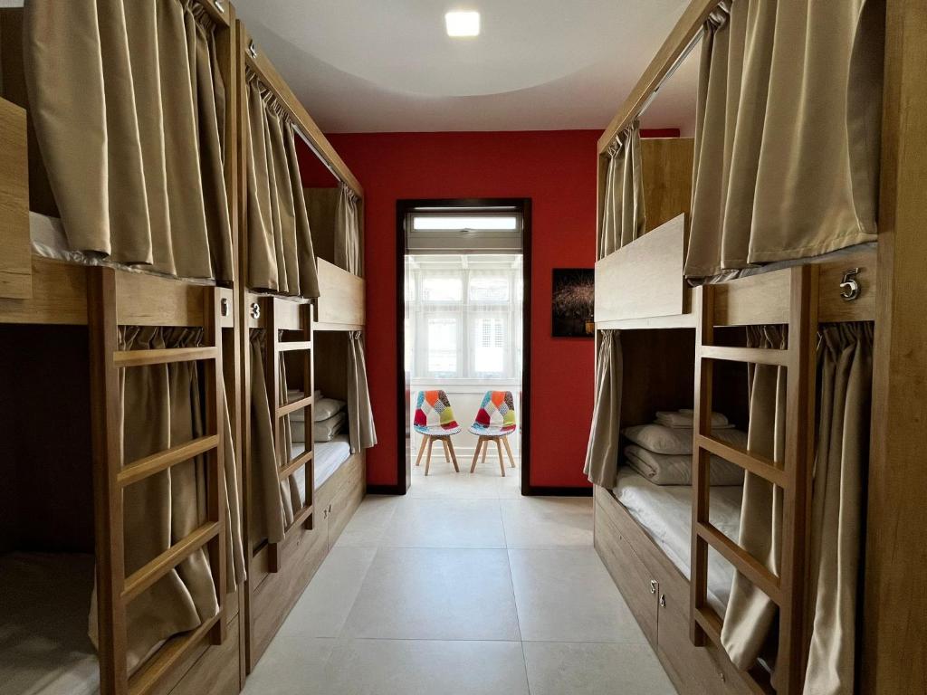 a room with bunk beds and a red wall at Central Hostel Malta in Birkirkara