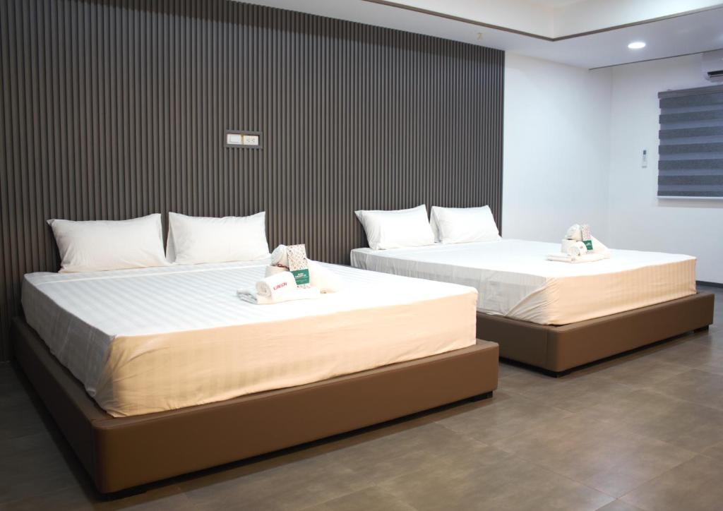 two beds in a room with two bedsitures at Koregon Hotel in Fort Stotsenburg