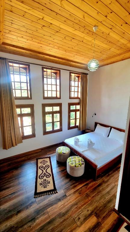 a bedroom with a large bed and a wooden ceiling at Sorlesa in Gjirokastër