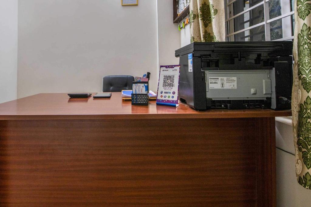 a desk with a microwave and a computer on it at Hotel O Sagar Comforts in Bangalore