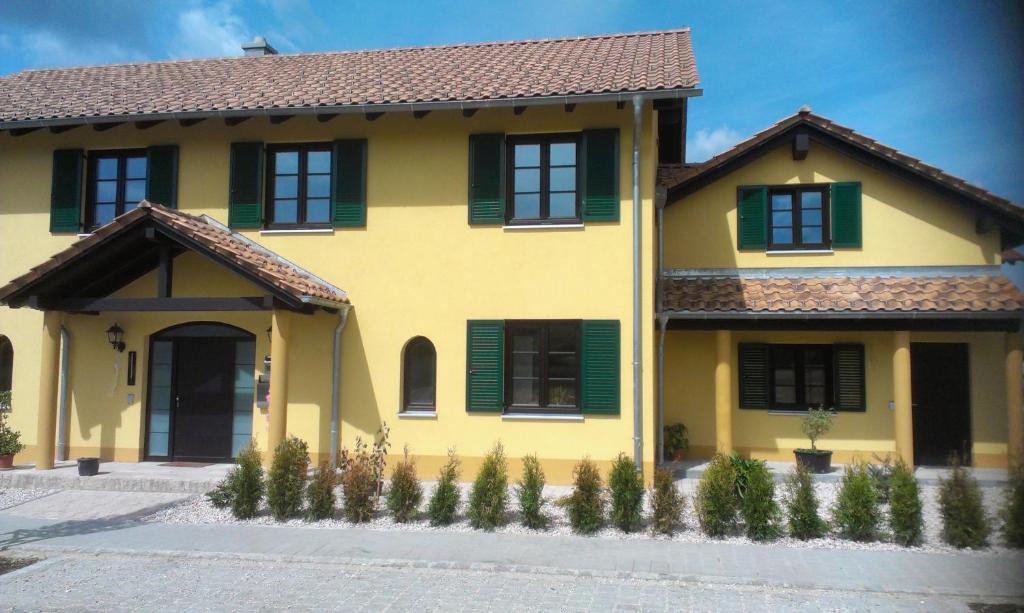 a yellow house with green shutters on it at Ferienwohnung Emmert Landshut in Landshut