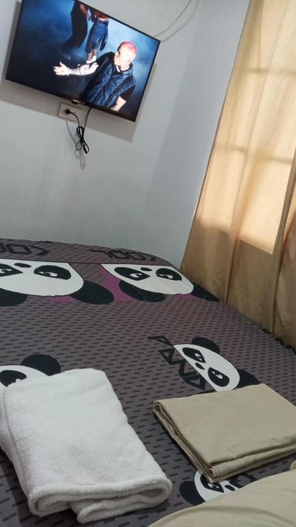 a bedroom with a bed and a tv on the wall at El viajero relax in Malambo