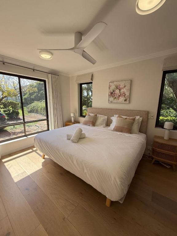 a bedroom with a large bed with a ceiling fan at Amazing 3bd in National Park in Bundeena