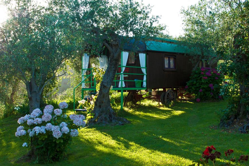 a tree house in a yard with flowers at Azienda agricola Della Mezzaluna in Stiava