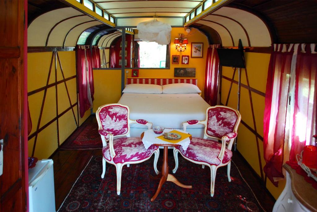 a bedroom with a table and chairs in a train car at Azienda agricola Della Mezzaluna in Stiava